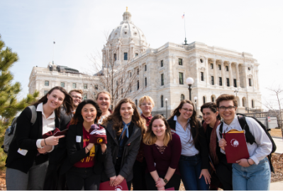 A group of students posing with MN state capitol in background